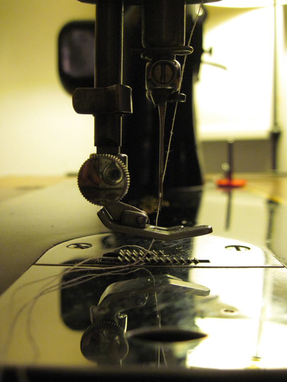 A profile view of the presser foot and needle bar.