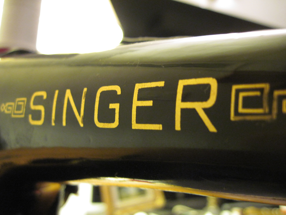 A closeup of the Singer decal on the back of the machine's arm.