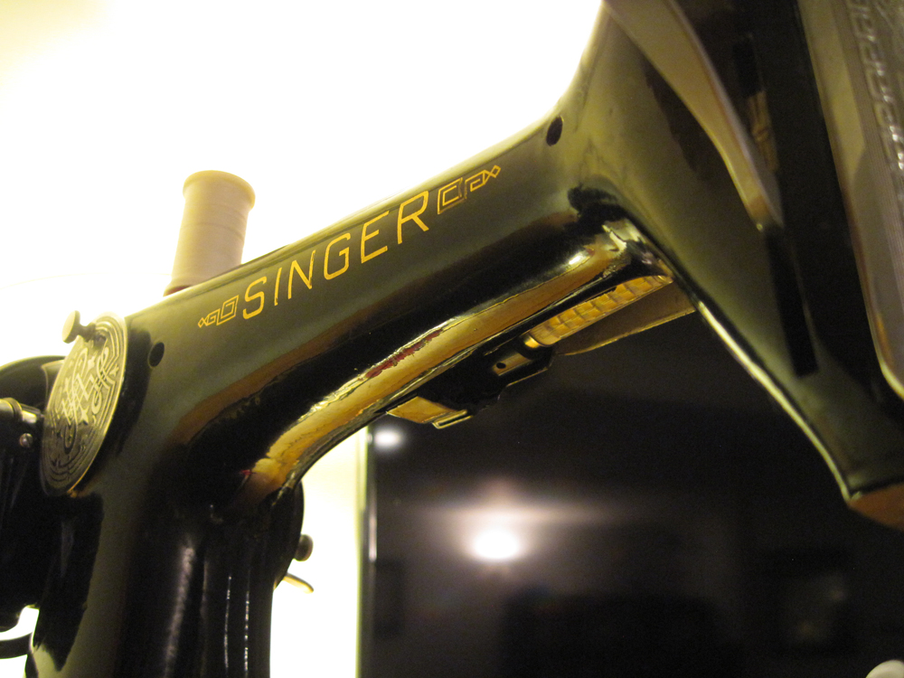 A view of the machine from the backside. The arm of the machine displays a Singer decal.