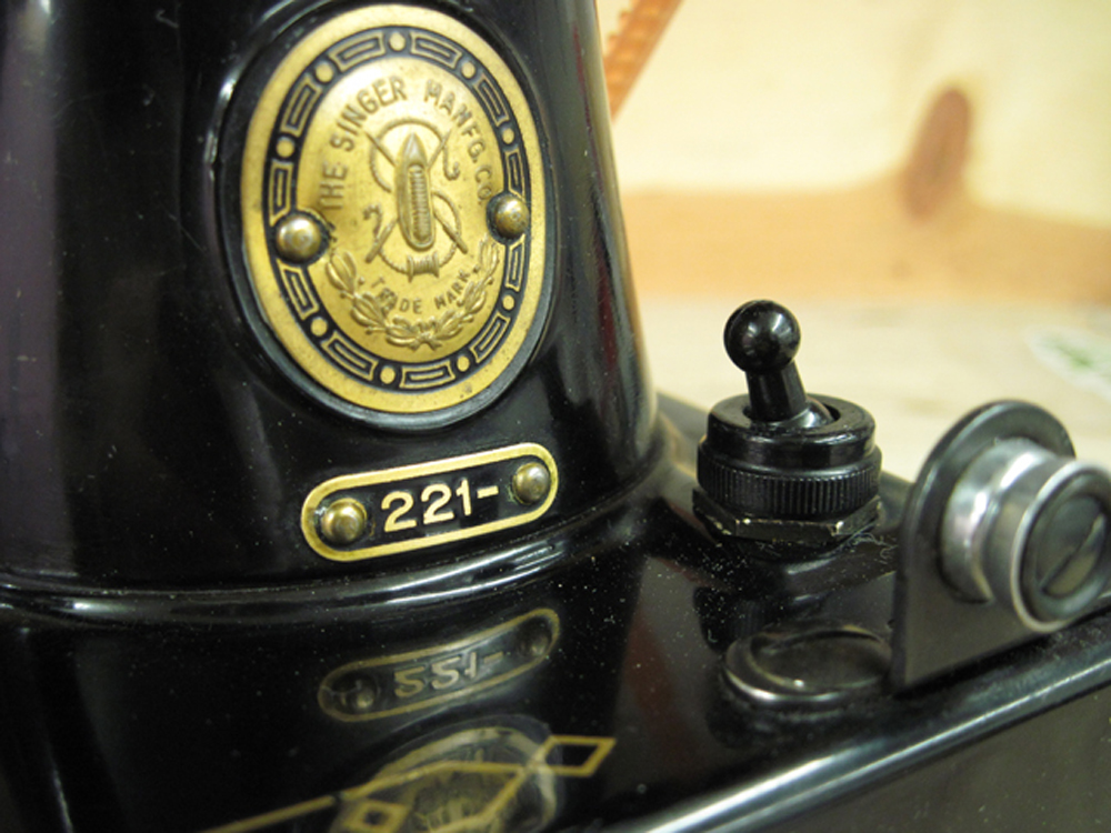 A closeup of the Singer logo and model number badges. 