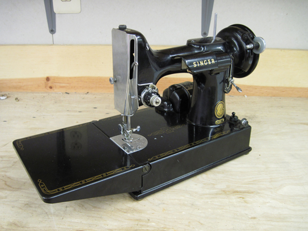 A black Singer Featherweight Model 221 sewing machine, viewed from the front.
