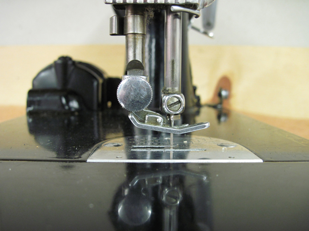 The needle bar, viewed from the left side of the machine.