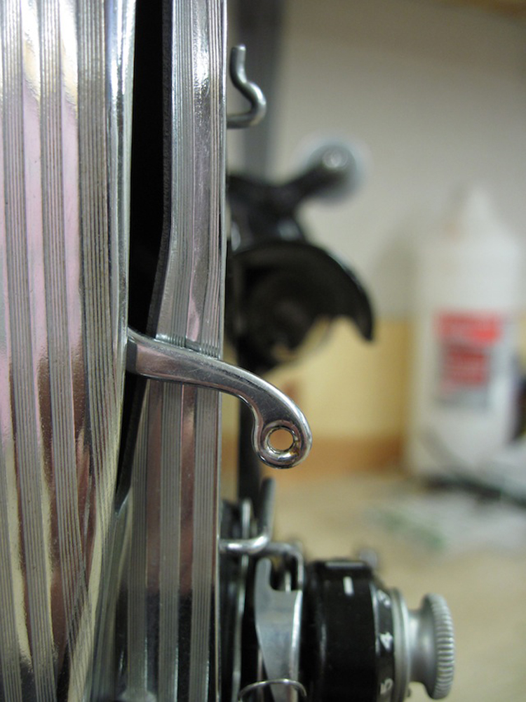 A closeup of the stitch takeup arm.
