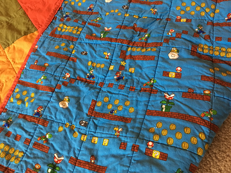 The backing fabric is mario themed, showing Mario and Luigi jumping through an intricate level design with lots of enemies.