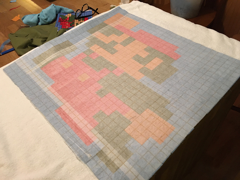 The back of a 20-inch by 20-inch square of interfacing, through which the Mario design visible on the reverse side.